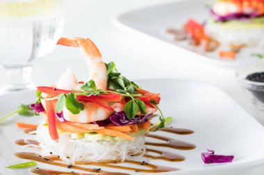 Tabağına Asya sosu serpiştirilmiş salata rulosunun yakın plan resmi..