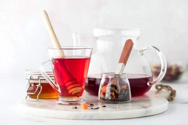 stock image A close up of hibiscus tea with honey against a light back ground.