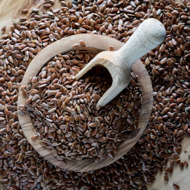 Küçük bir ahşap kase ve keten tohumlarıyla dolu ahşap kepçe. 