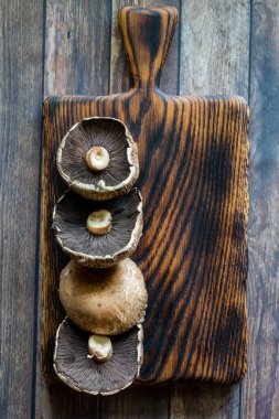 Portobello mantarları ahşap bir tahtanın üzerinde, ahşap bir masanın üzerinde..