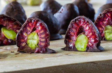 Ahşap bir tahtanın üzerinde, çikolata kaplı ahududu dolu şam fıstığı manzarası..