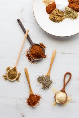 Taco baharat karışımı yapımında kullanılan dağınık kaşıkların yukarıdan görünüşü. 