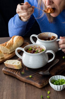 Tanınmayan bir kadının bir kase dolusu kırmızı biberden bir kaşık dolusu almasına yakın çekim.. 