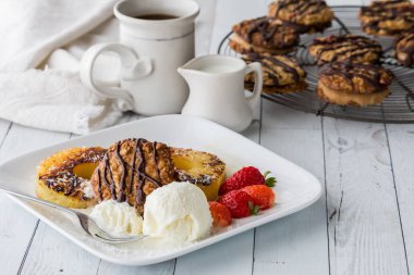 Hindistan cevizli ve vanilyalı dondurma ve çikolatalı dantelli kurabiye ile servis edilen ananas halkalarından oluşan tatlı bir tatlı..