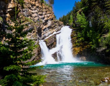  Güneşli bir günde popüler bir turizm merkezi olan Waterton, Alberta 'daki Cameron Falls' un manzarası..