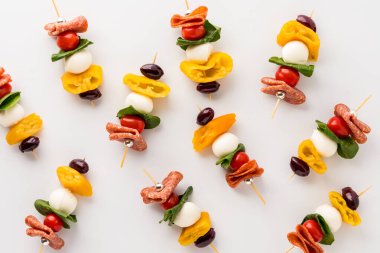 Fresh and tasty homemade antipasto skewers against a white background. 
