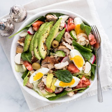 Tavuklu, avokadolu ve yumurtalı büyük taze bir salata, yenmeye hazır.. 