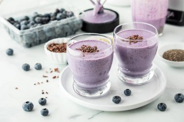 Kakao parçacıklarıyla kaplanmış taze yapılmış sağlıklı yaban mersinli smoothie bardakları.. 