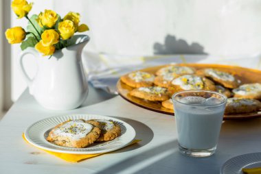 Ev yapımı limonlu haşhaşlı kurabiyeler parlak güneş ışığında masada..