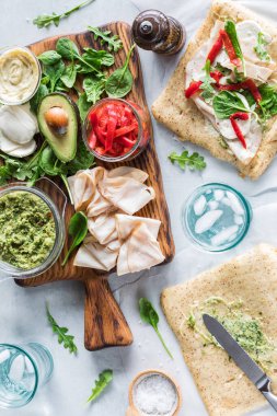 Ahşap bir tahtanın üzerinde pesto hindi sarması yapmak için taze malzemeler.. 