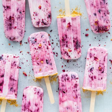 Gül yaprakları serpiştirilmiş vişneli yoğurt. Kare mahsul.