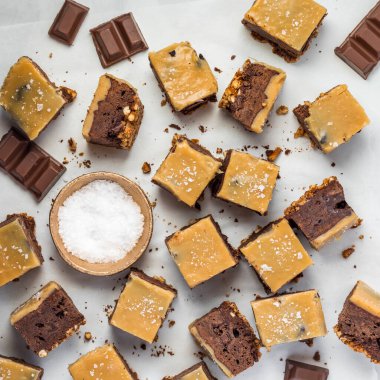 Parşömen kağıdına dağılmış tuzlu karamelli kraker, alt browni manzarasının üstünde.. 