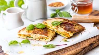 Yumurtalı ve eritilmiş gouda peynirli sandviç, ballı ve yemeye hazır..