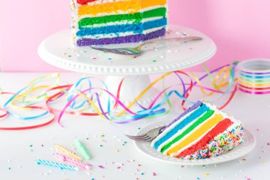 Pastanın geri kalanıyla birlikte bir dilim gökkuşağı pastası yakın plan..