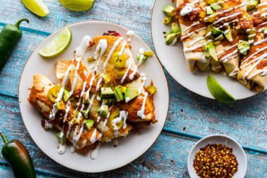 Üzerine salsa, avokado ve ekşi krema serpiştirilmiş ev yapımı taquitos manzarası.. 