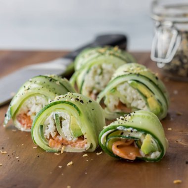 Ev yapımı salatalıklı suşi ve ahşap bir tahtanın üzerinde simit sosu.. 