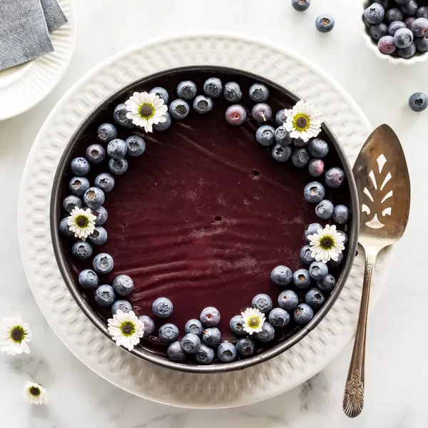 stock image Top down view of a homemade blueberry cheesecake topped with fresh blueberries, ready for serving.