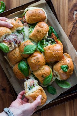 El yapımı İtalyan sandviç tepsisinden çörekleri çeken eller.. 