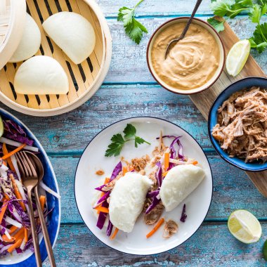 Ev yapımı domuz eti ve buğulanmış bao çörekleri tabakta yenmeye hazır.. 