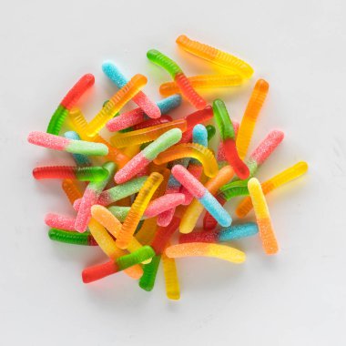 Renkli jelibon solucanlarından oluşan yığının üzerinde hafif bir arkaplan karşısında.