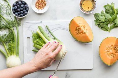 Sağlıklı bir salata için taze rezene kesen bir el.. 