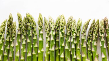 Beyaz arka plana karşı art arda taze kuşkonmaz mızrakları.. 