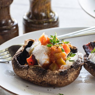 Portobello mantar yumurtalarının yakın plan çekimi. Benedict soslu ve kekikli, yemeye hazır..