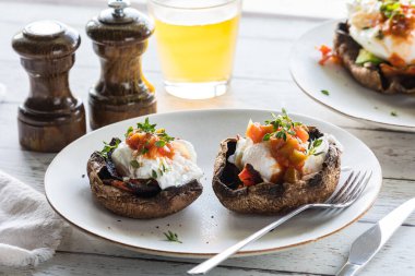 Portobello mantarlı, Benedict yumurtalı ve salsa soslu portobello porselenlerine yakın çekim.. 