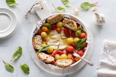 Kızarmış domates ve peynirli aperatifin üstünde batırmak için ekmek parçaları var..