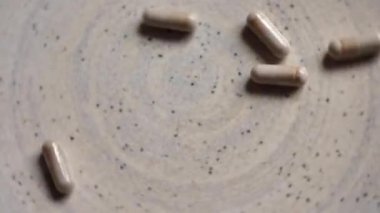 Bir sürü gri vitamin demir hapını birbirine yaklaştırıyor. İlaçlar. Statik çerçeve. Gri plaka üzerinde döndür