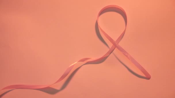 乳がんの病気のシンボルとピンクのリボン世界の白い背景にクローズアップがん啓発日2月4日 コンセプト — ストック動画