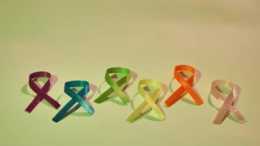 Cancer disease symbol with colored ribbons close-up on world Cancer Awareness Day , colored light