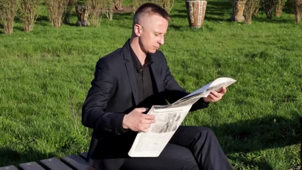 Egy Fiatal Komolyan Üzletember Üzleti Öltönyben Újságpapírt Tart Olvas Odakint — Stock videók