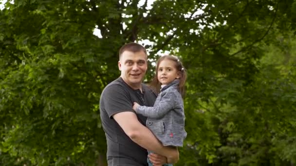 在国际父亲节这天 快乐的年轻爸爸和小女儿在户外绿树成荫的公园拥抱 享受和欢笑 — 图库视频影像