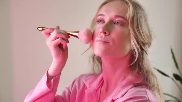 自然金发女人用粉红霓虹灯的刷子做芭比娃娃妆容 新娘涂上粉末 脸红了 准备在婚礼前参加一个单身派对 — 图库视频影像