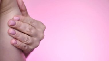 Küçük göğüslü, AA beden, göğüs masajı yapan ve göğüs kanseri kontrolü yapan, yakın plan, pembe ışıklandırmalı bir kadın. Bir mamologda kendine ve sağlığına önem veriyorsun. Kadın vücudu izole edildi