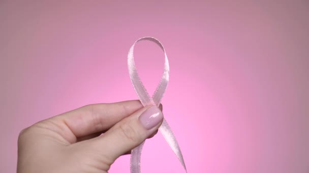 粉红的象征丝带在手上 世界乳腺癌日 粉红霓虹灯背景 专业照明 — 图库视频影像