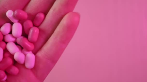 スイーツ キャンディー 手でピンクのティックタック 夏2023トレンド バービースタイルのクローズアップ ネオンマゼンタプロスタジオ照明 — ストック動画
