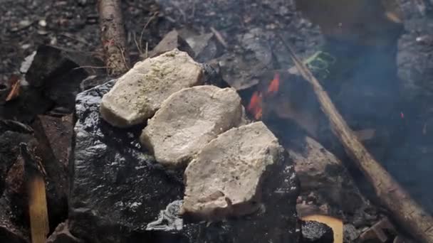 고기를 요리하고 바위에 스테이크를 준비하고 자연계에서 요리를 조명탄 — 비디오