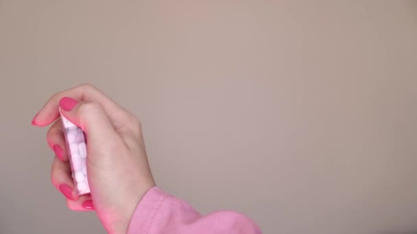 スイーツ キャンディー 手でピンクのティックタック 夏2023トレンド バービースタイルのクローズアップ ネオンマゼンタプロスタジオ照明 — ストック動画