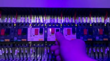 Elektrik kontrol paneli devre kesicilerle elektrik arzı ve daimi elektrik dağıtımı için konut sağlıyor. Mühendis kablolu bağlantı terminalini açıyor..