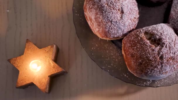 一个甜甜甜圈与粉糖庆祝犹太人的节日光明节在家里 蜡烛的大卫之星 靠近点 — 图库视频影像