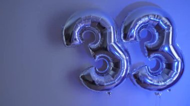 Party Happy Birthday Thirty-Three with Silver Grey number . Gel balls 33 for congratulations celebrations holiday. Close-up, neon lighting, no people