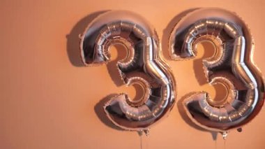 Party Happy Birthday Thirty-Three with Silver Grey number . Gel balls 33 for congratulations celebrations holiday. Close-up, neon lighting, no people