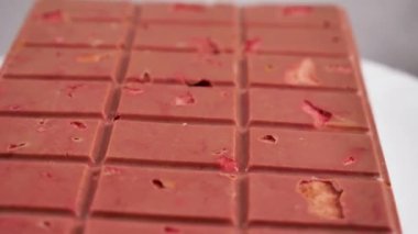 Dondurulmuş çilek ve bademle birlikte yakın plan pembe yakut çikolatası. Böğürtlen ve fındığa dayalı sağlıklı bir tatlı
