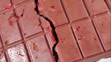 Dondurulmuş çilek ve bademlerle birlikte yakın plan pembe yakut çikolatası. Böğürtlen ve fındığa dayalı sağlıklı bir tatlı