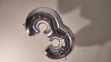 Bej bir duvara karşı 33 numaralı formda gümüş balonlar. İki balon altta birbirine bağlı. İyi ki doğdun