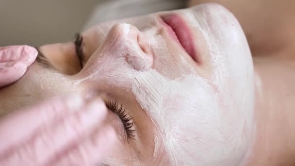 Profesjonalny Kosmetolog Nakłada Białą Maskę Twarz Klientki Pędzlem Zbliżenie — Wideo stockowe