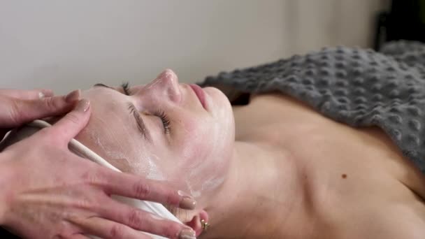 Een Ervaren Cosmetoloog Massage Therapeut Voert Een Ontspannende Gezichtsmassage Voor — Stockvideo