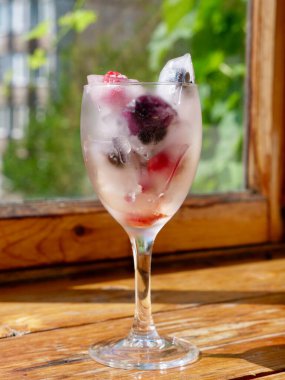 Mevsimlik vitamin vitaminleri, ahududu, çilek, kiraz, yaban mersini, böğürtlen, böğürtlen, böğürtlen ve meyvelerin korunması için dondurulmuş böğürtlen ve meyveli bir bardak.